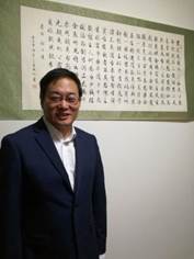 穿西装的男人站在墙边
描述已自动生成